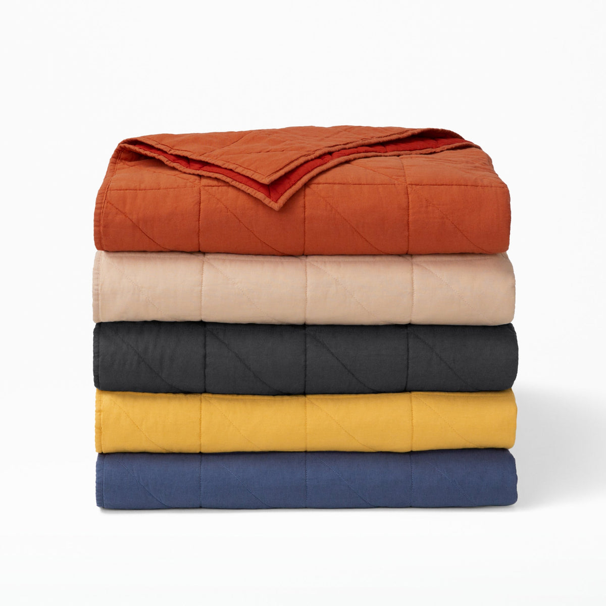 Stacked T&N quilts in an array of colors.