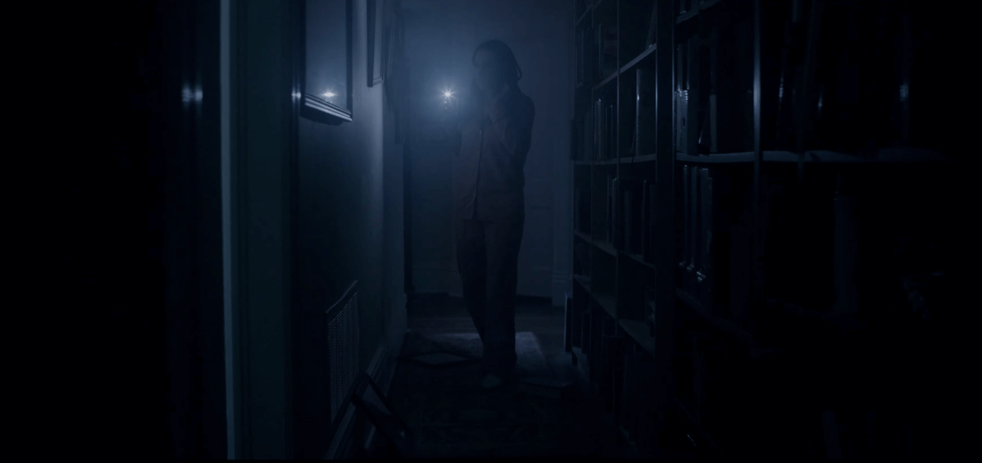 Picture of someone walking in the dark with a flashlight