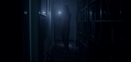 Picture of someone walking in the dark with a flashlight