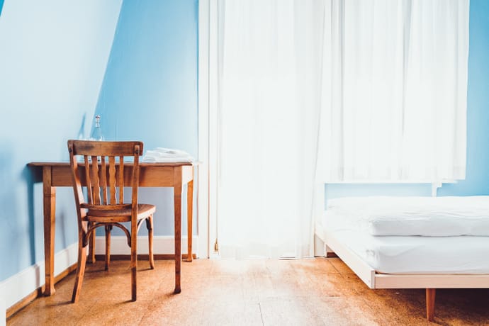Light blue room with bed and desk