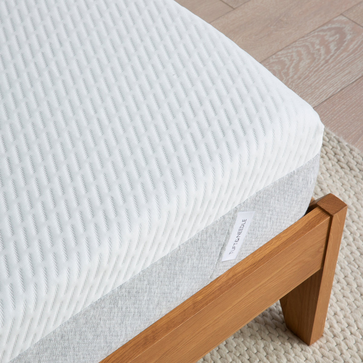 TN Original Mattress sitting in a wooden bed frame on top of a beige rug