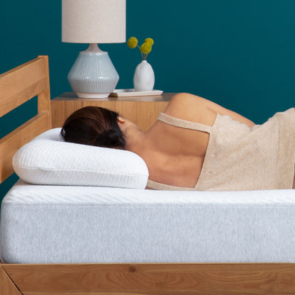 Woman lying on a Tuft and Needle mattress on her left side with her head on the pillow.