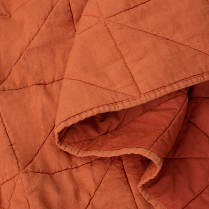 Close-up view of the fabric on the Tuft and Needle Quilt color cayenne