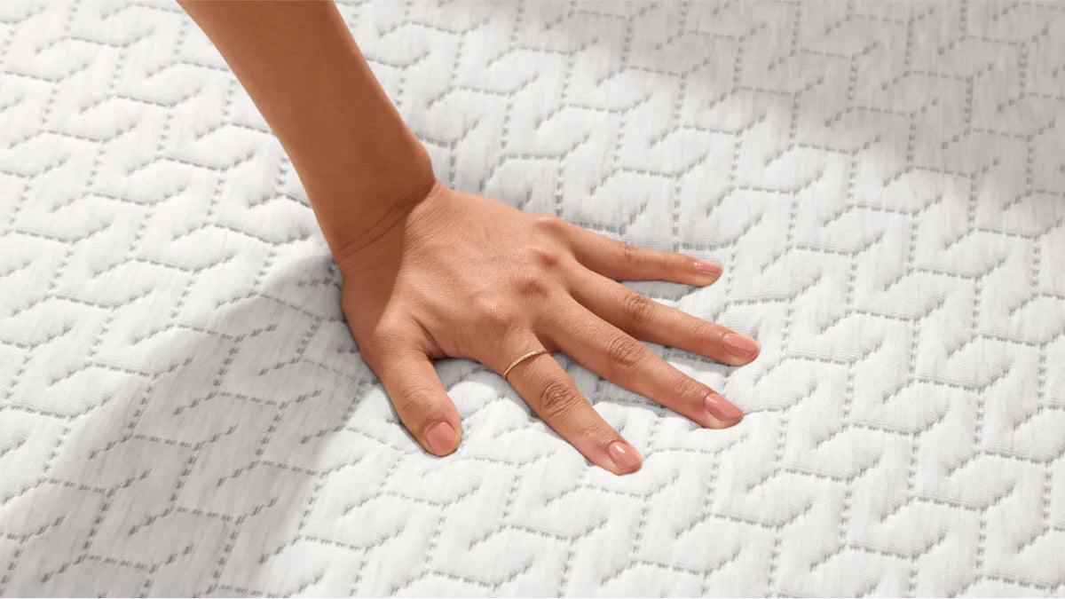 woman's hand pressing on to a foam mattress