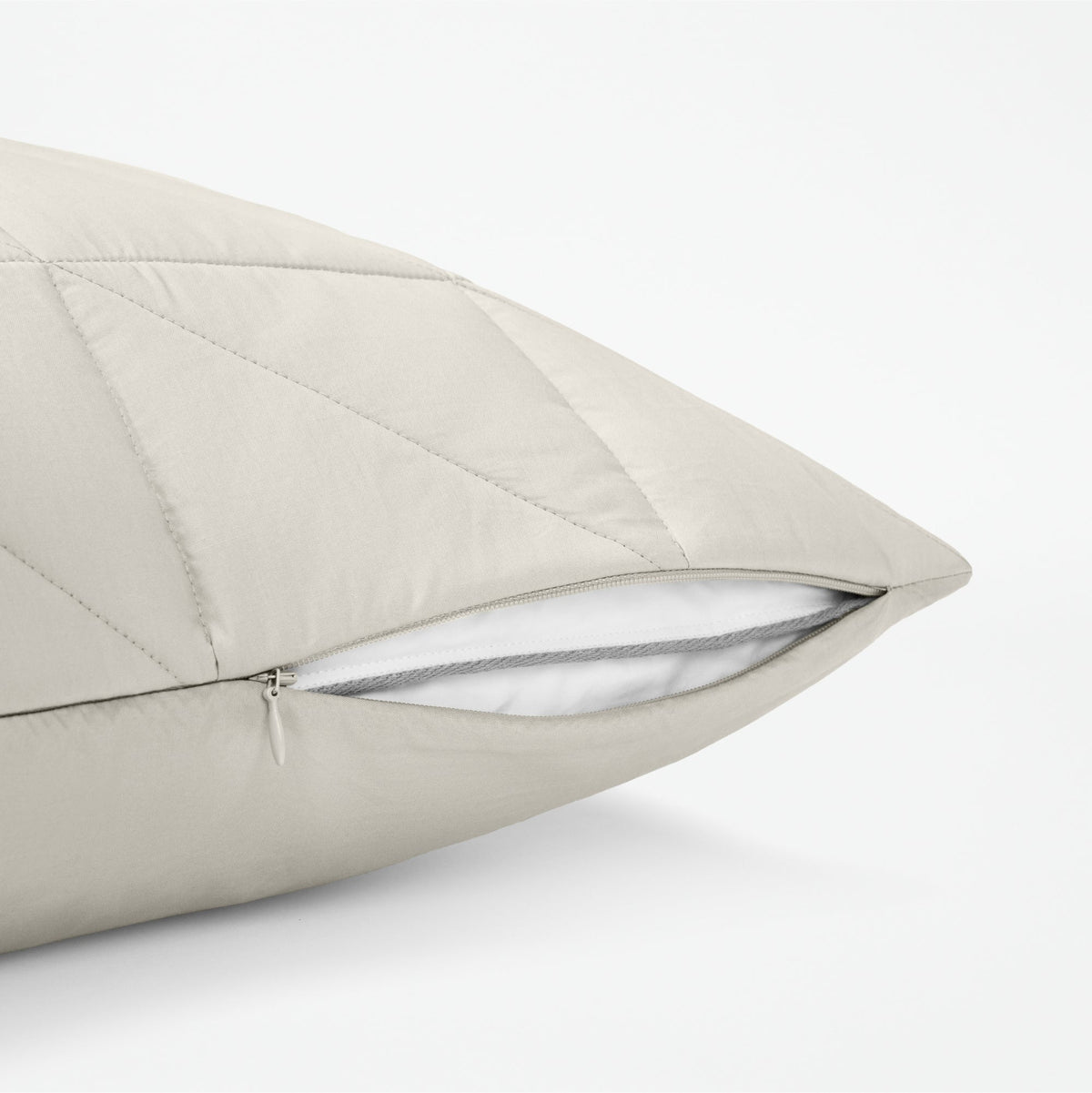 The Tuft and Needle Classic Percale Body Pillow Cover, showing a zipper slightly open to the pillow inside || color: Sand

