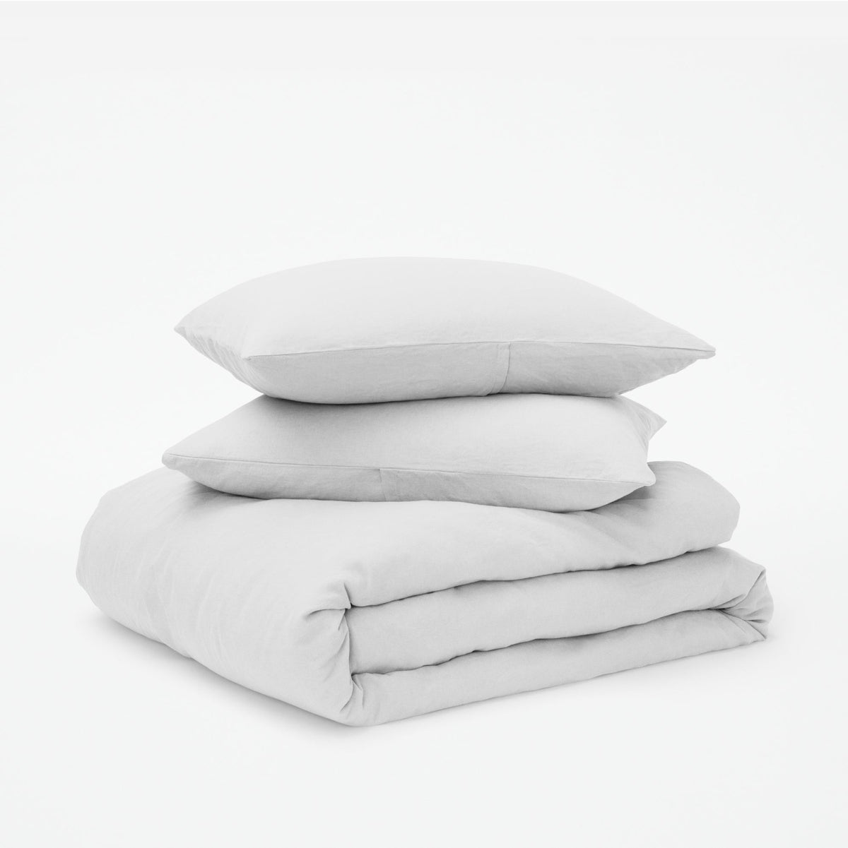 The Tuft and Needle Linen-Cotton Blend Duvet Set, 2 pillows stacked on 1 duvet covered blanket || color: Cloud
