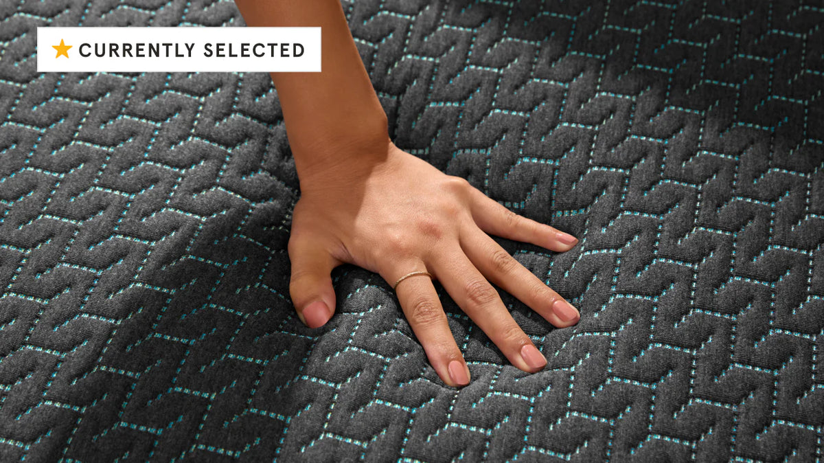 woman's hand pressing on to a hybrid mattress
