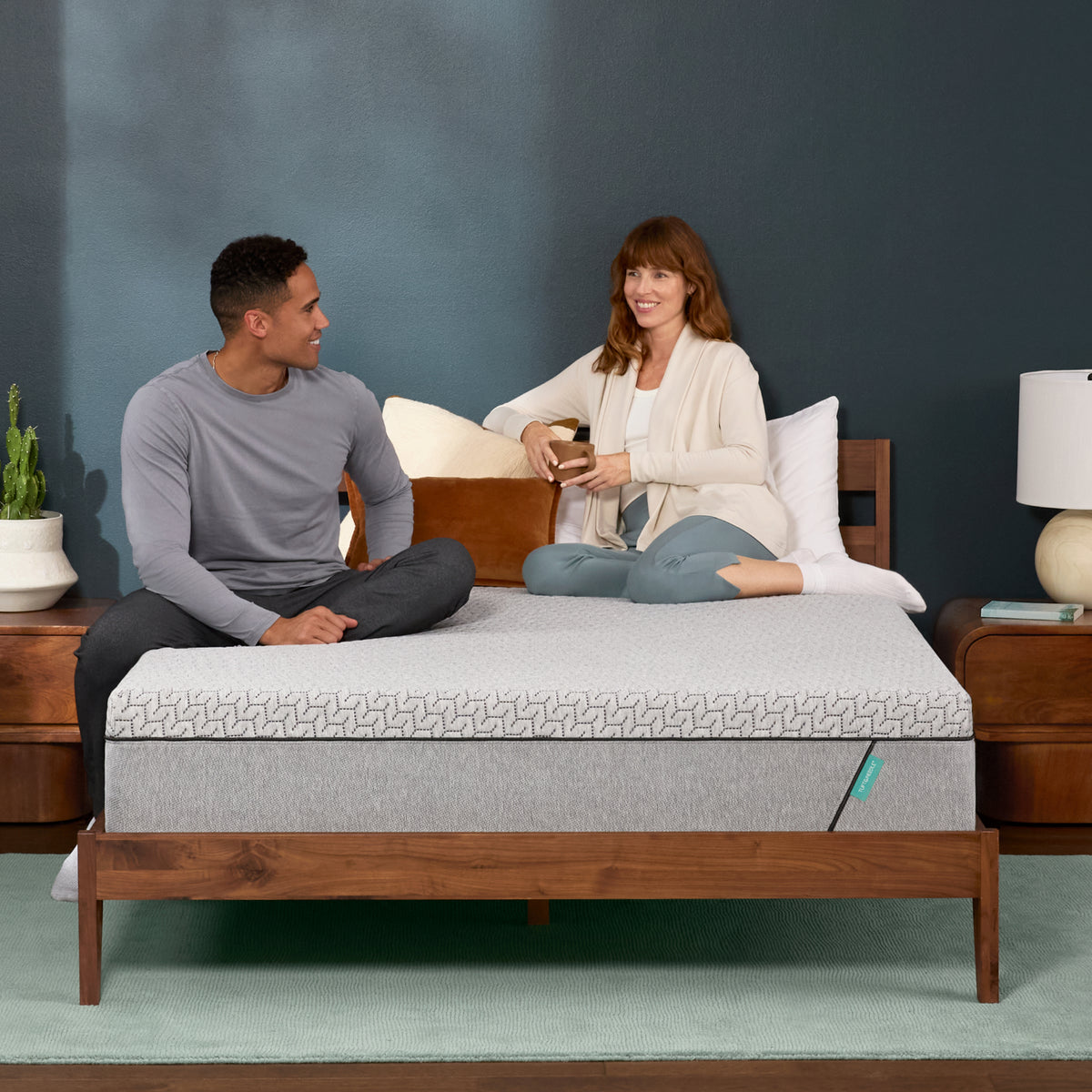 Couple sits on a mint mattress 