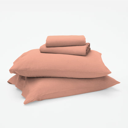 The Tuft and Needle Linen-Cotton Blend Sheet Set, 2 sheets stacked on 2 pillows || color: Muted Clay
