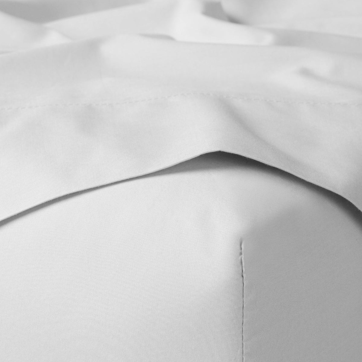 The Tuft and Needle Classic Percale Sheet Set, corner of a mattress with both sheets showing || color: Cloud

