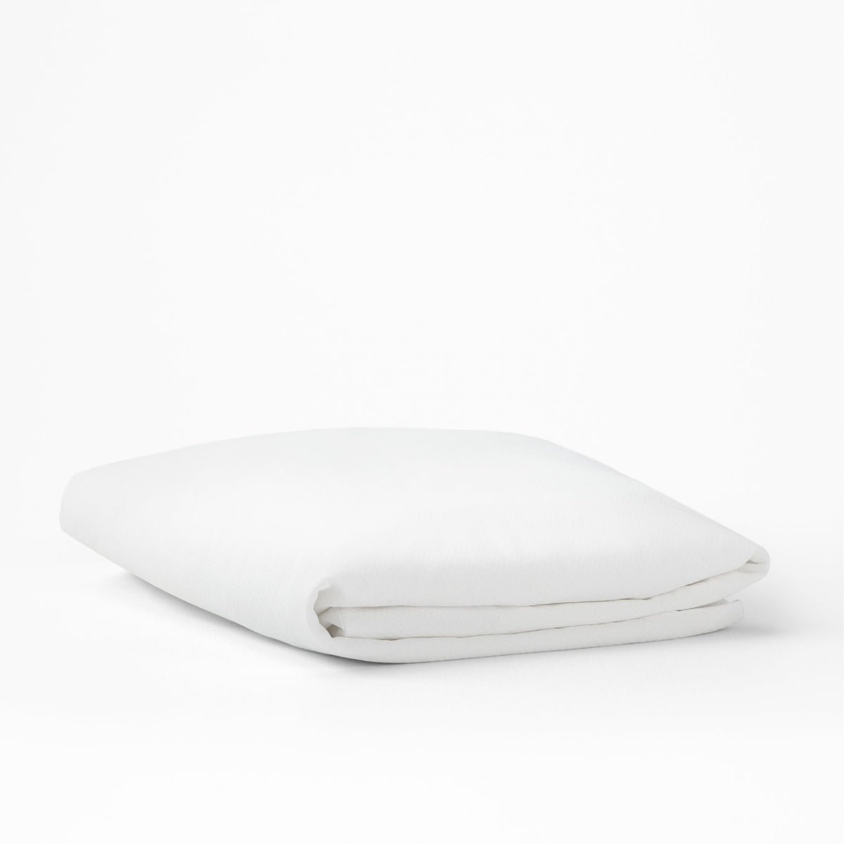 The Tuft and Needle Mattress Protector folded on a white background