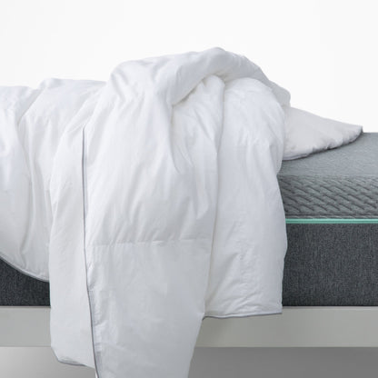 The Tuft and Needle Alternative Duvet Insert tossed on a bed in a bedroom||weight:light