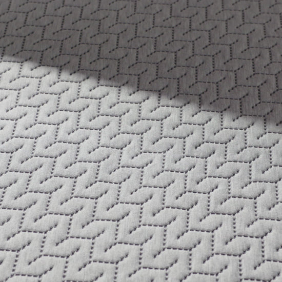 close up of a hand pressing into the top of the 12 inch foam mattress