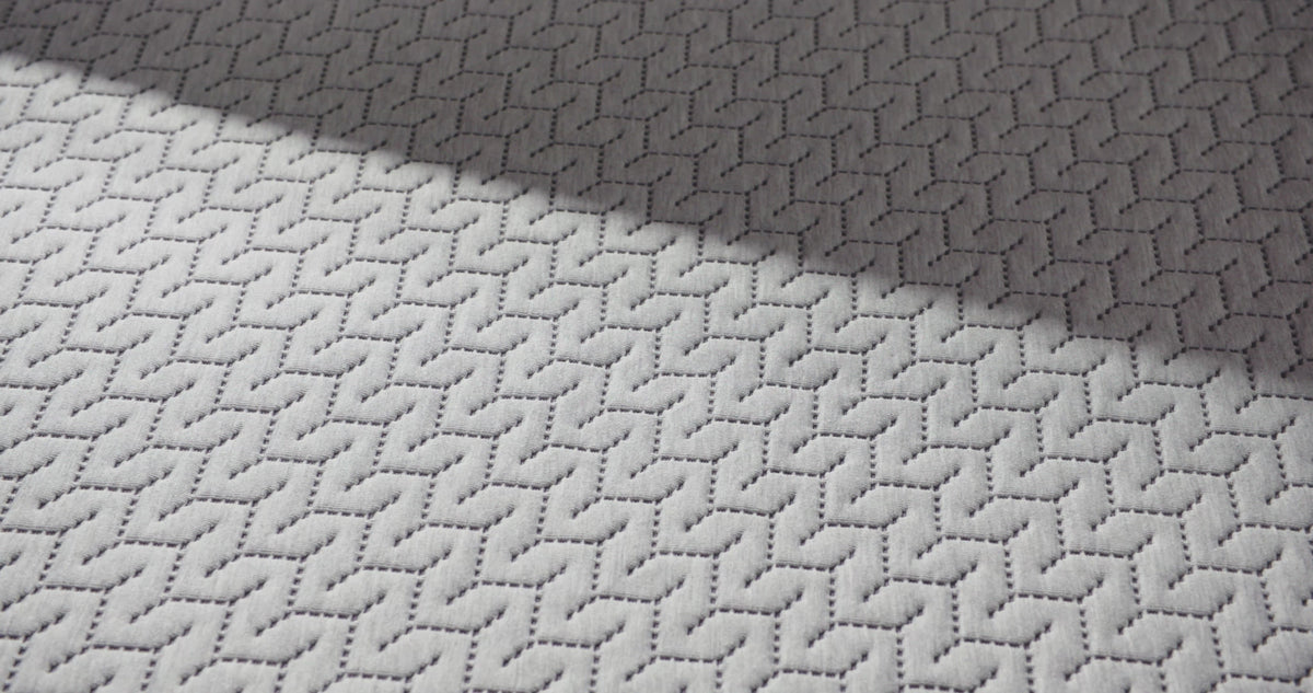 close up of a hand pressing into the top of the 12 inch foam mattress