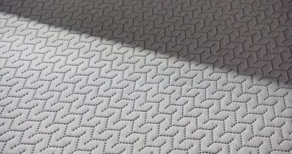 close up of a hand pressing into the top of the 12 inch foam mattress