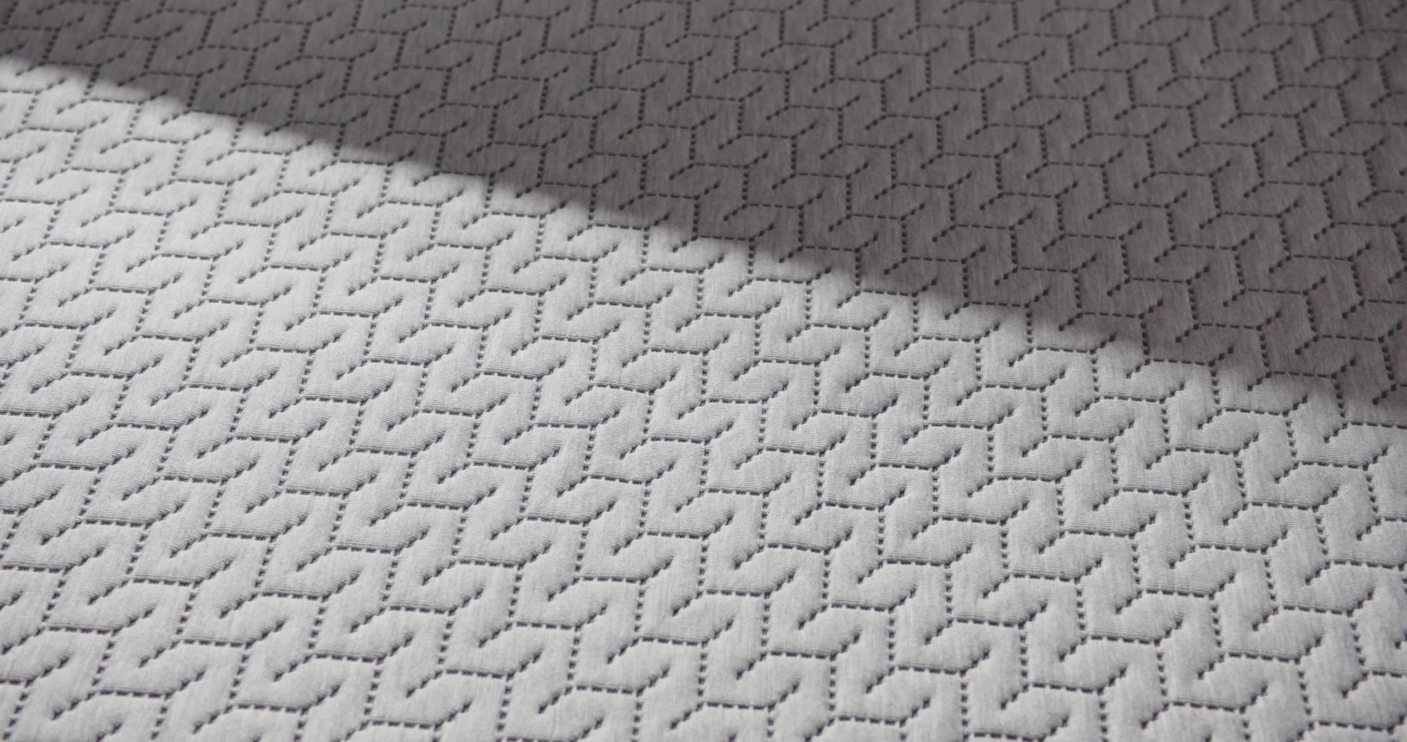close up of a hand pressing into the top of the 12 inch foam mattress