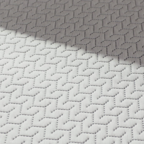 Person presses hand on a foam mattress.