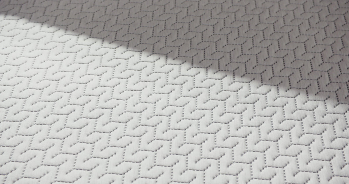 Person presses hand on a foam mattress.