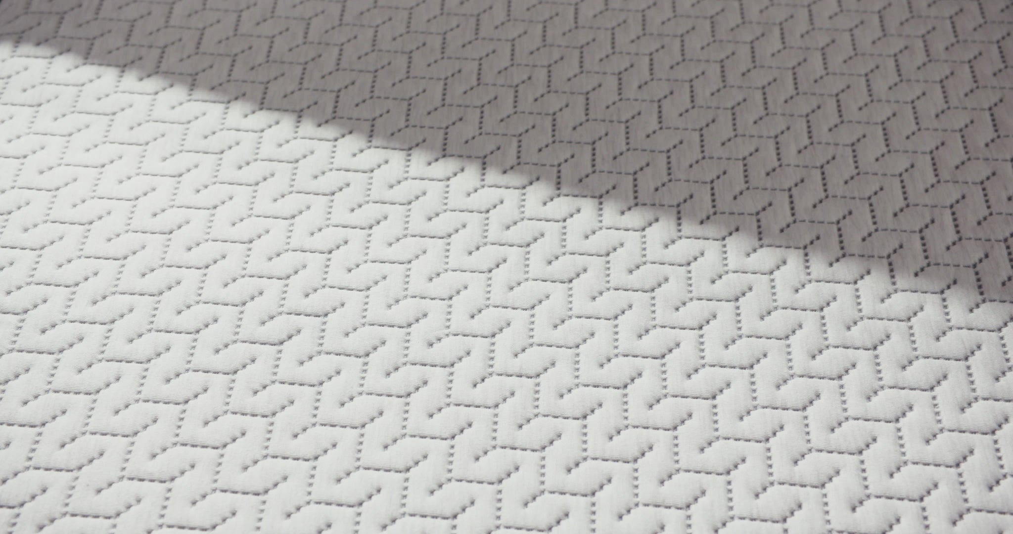 Person presses hand on a foam mattress.